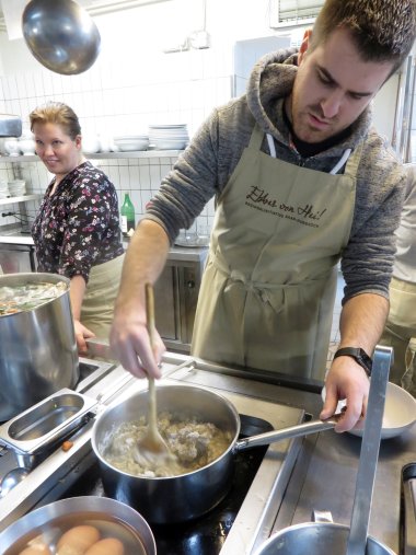 Ein Koch rührt in seine Töpfen